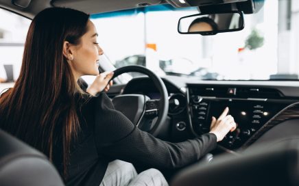 Young woman testing a car in a car showroom