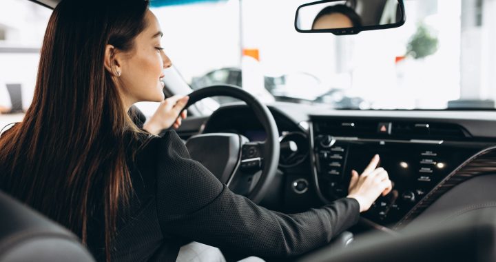 Young woman testing a car in a car showroom