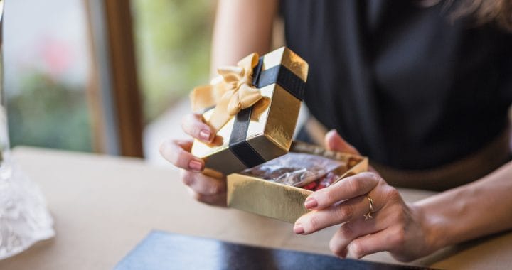 man woman opening present box table