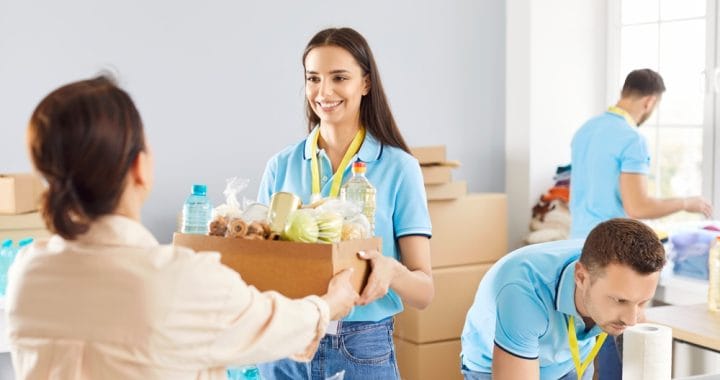 Young,Cheerful,Volunteer,Working,At,Charity,Center,And,Giving,Free