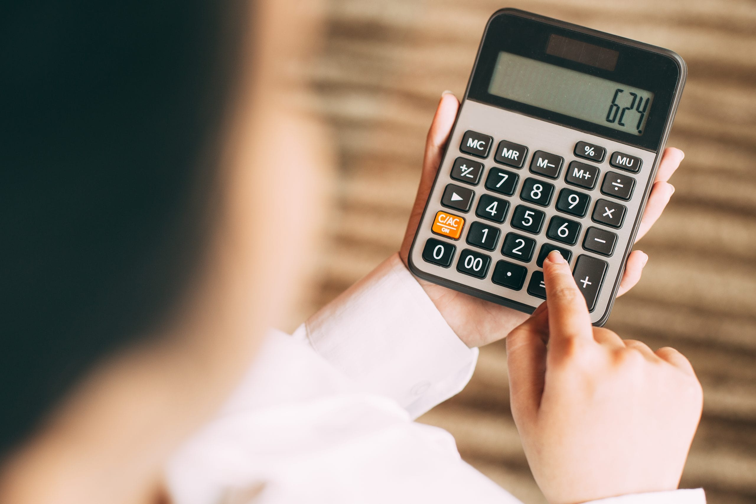 Businesswoman counting with calculator in office Businesswoman counting with calculator in office