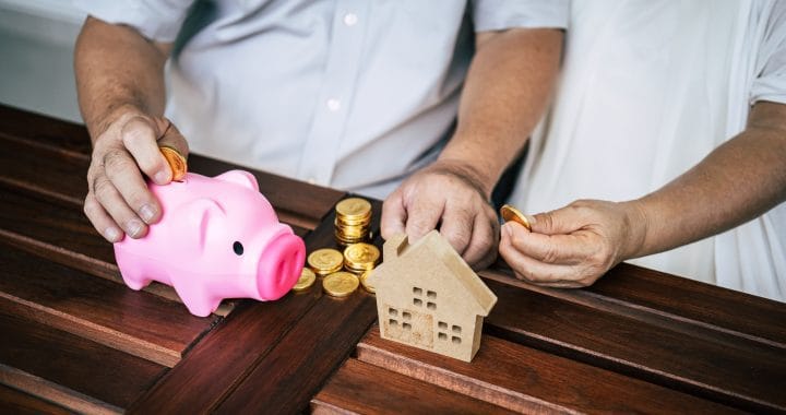 Elderly Couples talking about finance with piggy bank